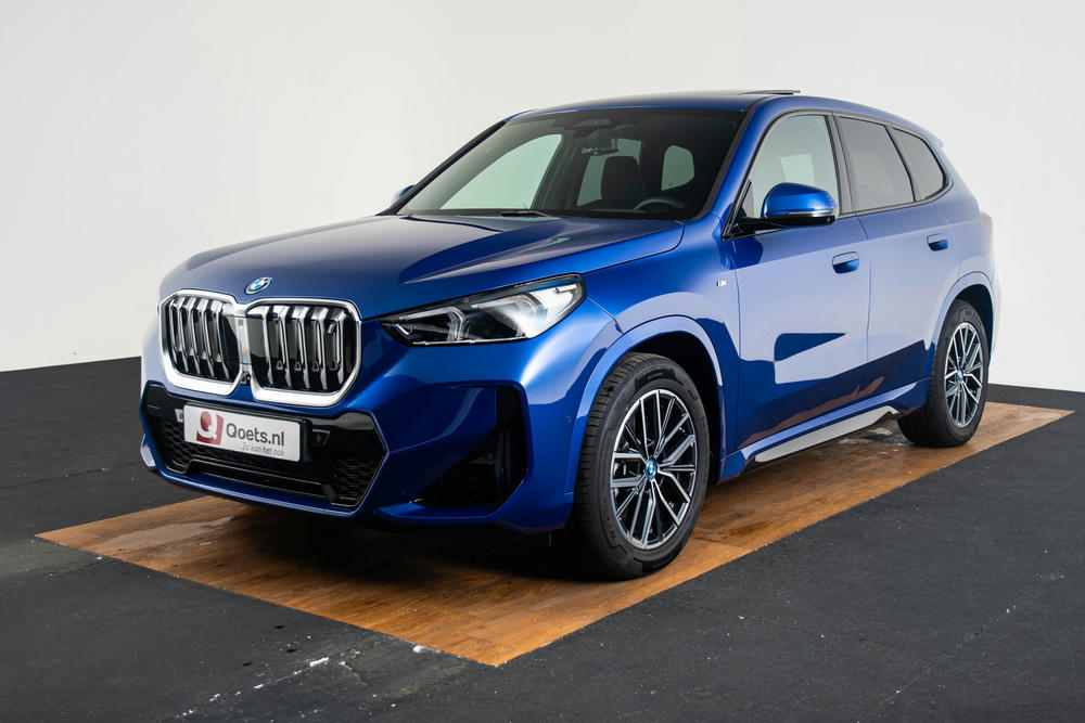 BMW iX1 linksvoor in de kleur Portimao Blauw