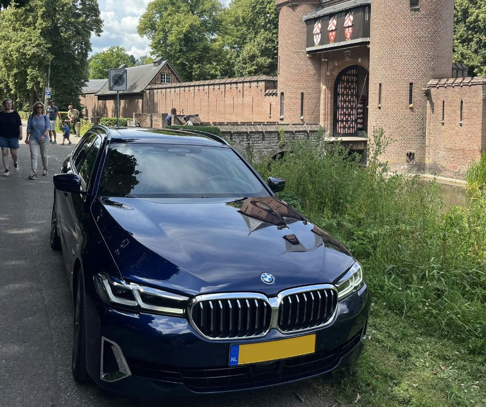 garmt zijn auto voor een kasteel